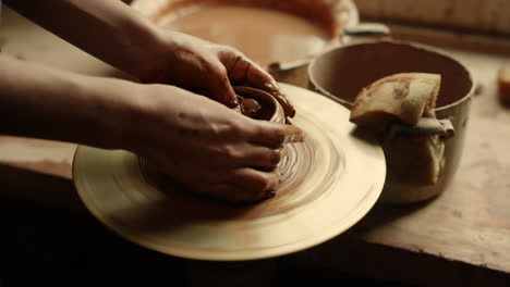 unknown girl working with potters wheel in studio. woman modeling clay product