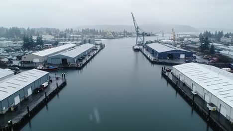 aerial view of a tranquil harbor with manufacturing facilities on a cloudy day, displaying the serene waterway between industrial structures