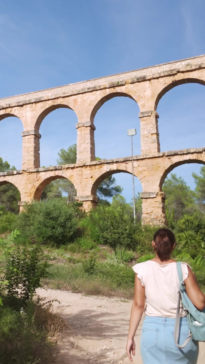 Donna che cammina verso l'acquedotto romano di Tarragona