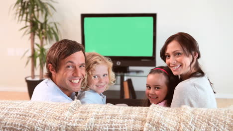 family sitting while watching the television
