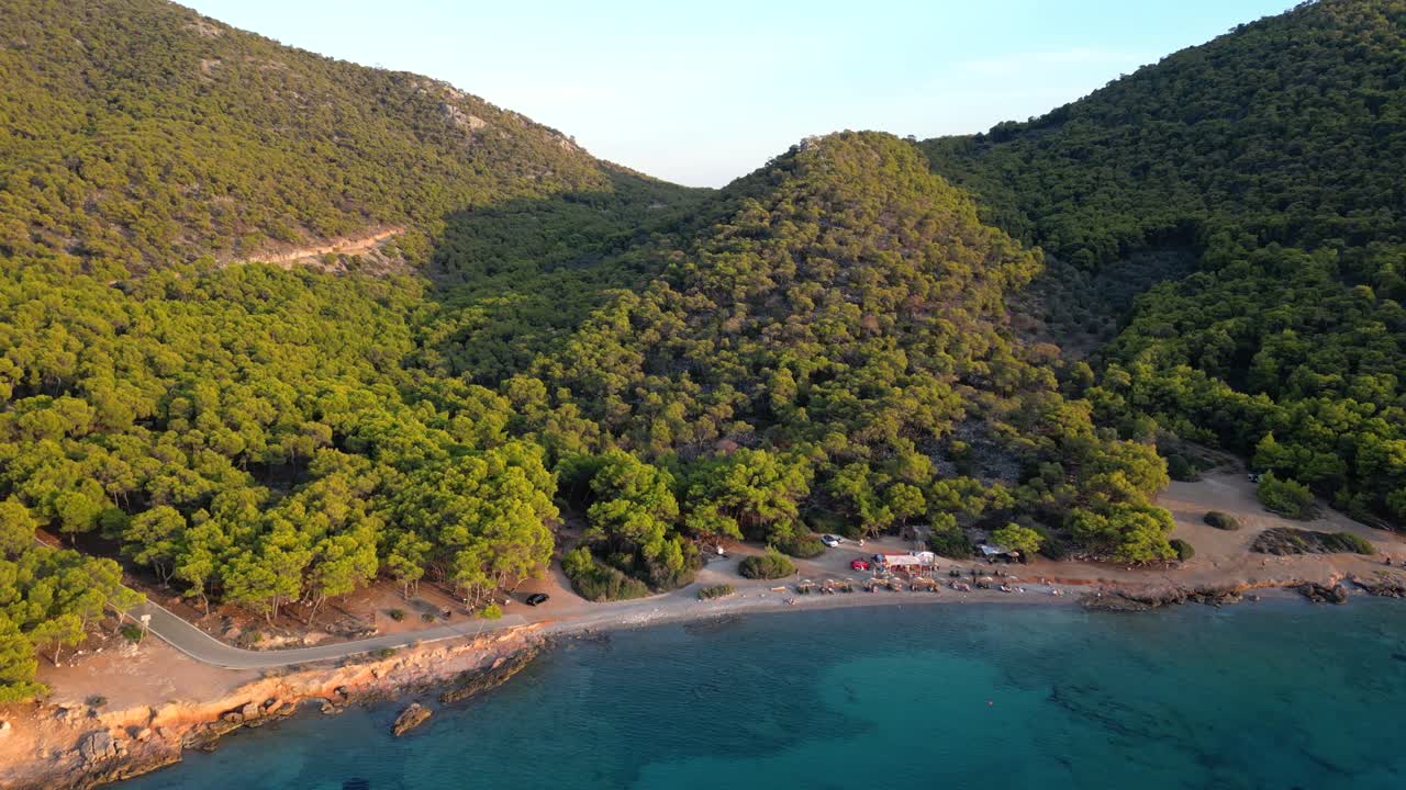 Cinematic drone tilt up view over beach with blue ocean and forest
