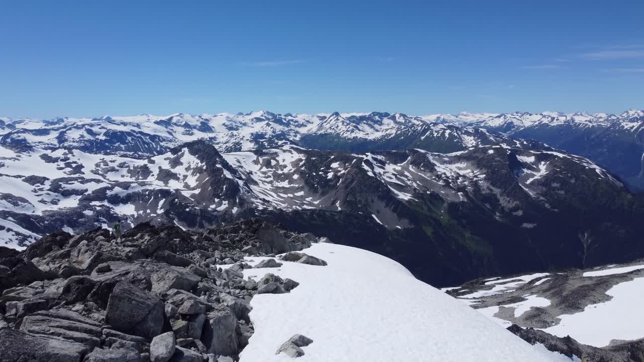 enorme paisaje montañoso de nieve con profundos valles desde el pico - empujando disparo de drone