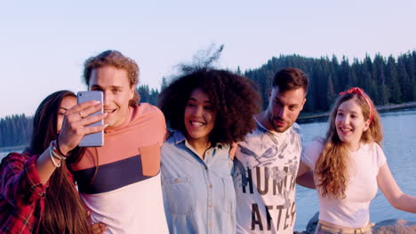 amigos tomando selfies junto al lago