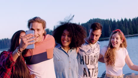 friends taking selfies by the lake