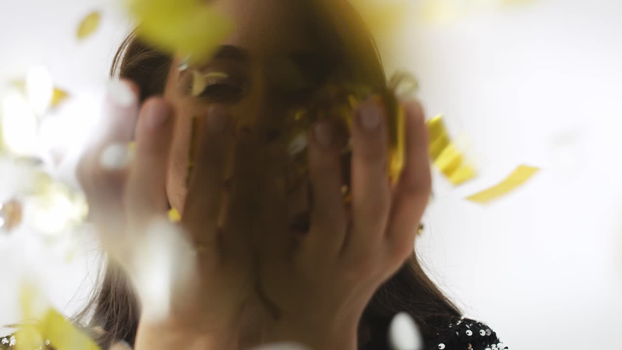 여성이 콘페티 조각을 불고 있는 전면 전망