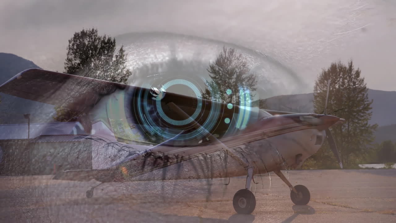 Digital eye animation over small airplane parked near trees and mountains