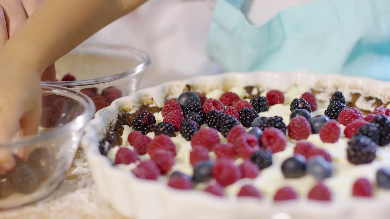 Bambina che sta ultimando una crostata di frutti di bosco fatta in casa
