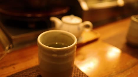 sequence of pouring tea into a cup on a table.