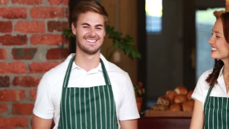 smiling waiter and waitress gesturing thumbs up