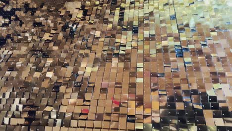 abstract background with flickering metallic or plastic particles wall, same size of shape of particles, real footage, a wall of golden sparkles spiked in the wind