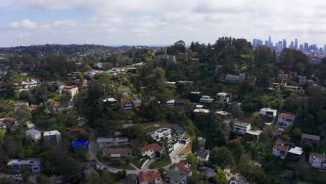 Reverse-pullback-aerial-shot-of-houses-on-the-hills-of-Silver-Lake-with-Downtown-Los-Angeles-in-the-background