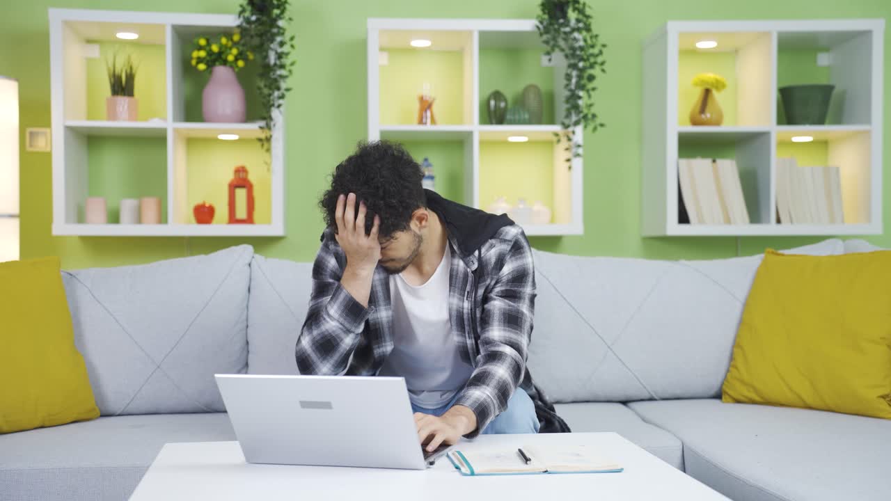 집에서 일하는 남자는 노트북에서 보는 것에 의해 스트레스를 받습니다.