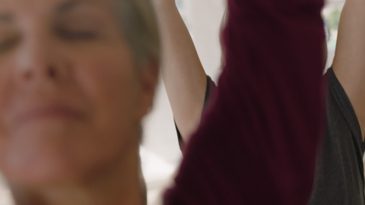 занятие йогой красивой женщины средних лет, практикующей позу воина, наслаждающейся здоровым образом жизни, групповая медитация в фитнес-студии