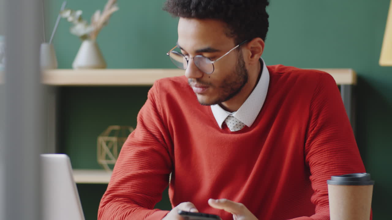 Young Man Using Smartphone in Modern Office