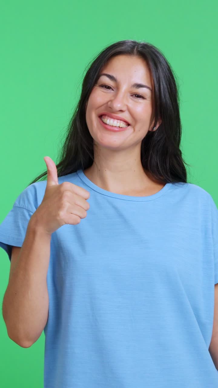 Mujer feliz y sonriente haciendo el gesto de pulgar arriba.