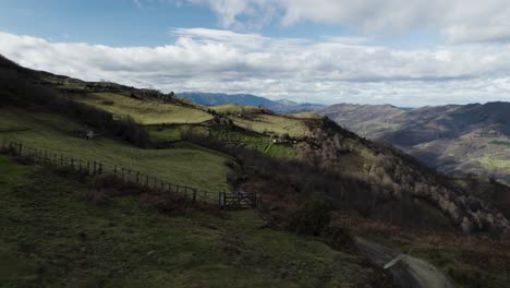 Acelerando-Sobre-Exuberantes-Campos-De-Hierba-Cercados-Entre-El-Hermoso-Paisaje-Montañoso