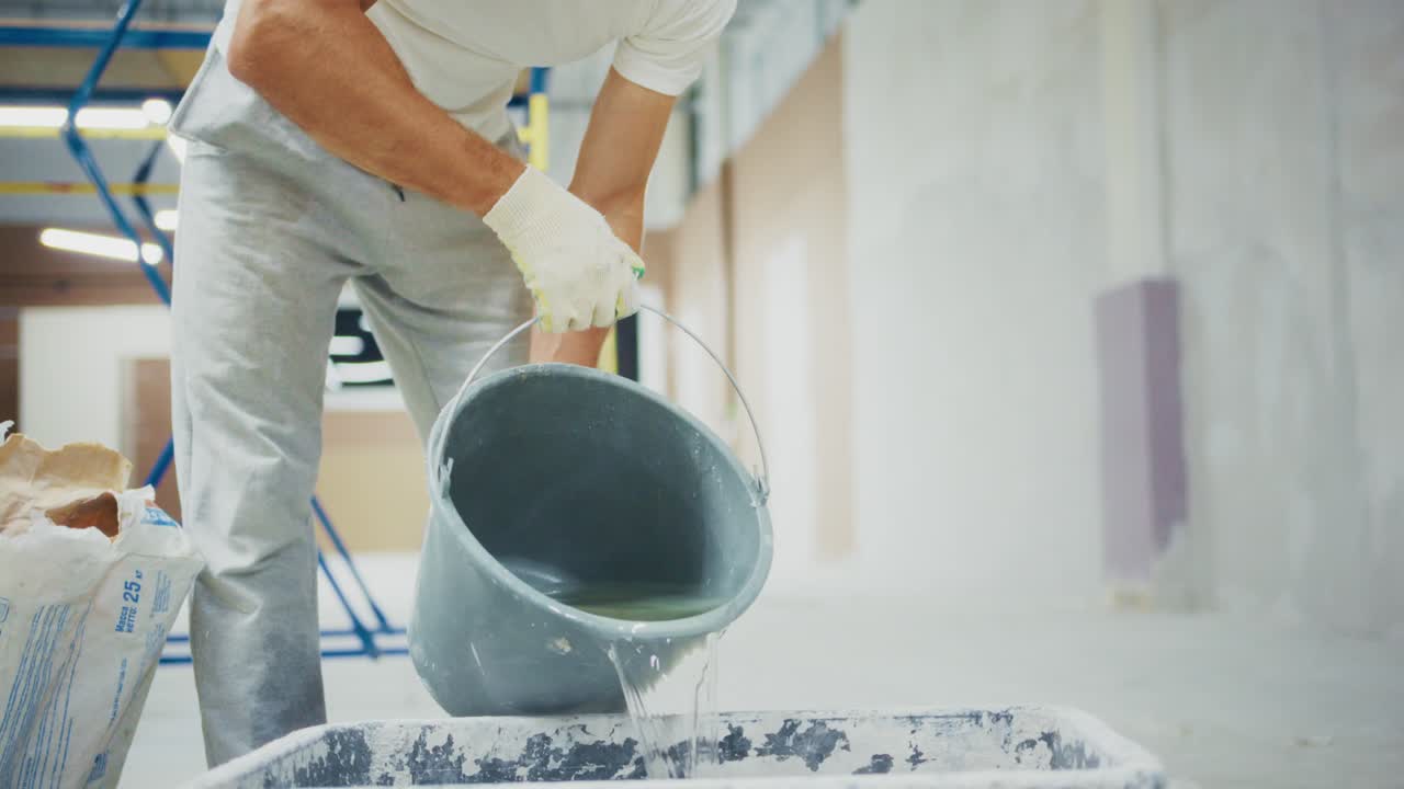 A dedicated worker transforms a space by preparing materials and using tools for construction in a modern building undergoing renovation and improvement