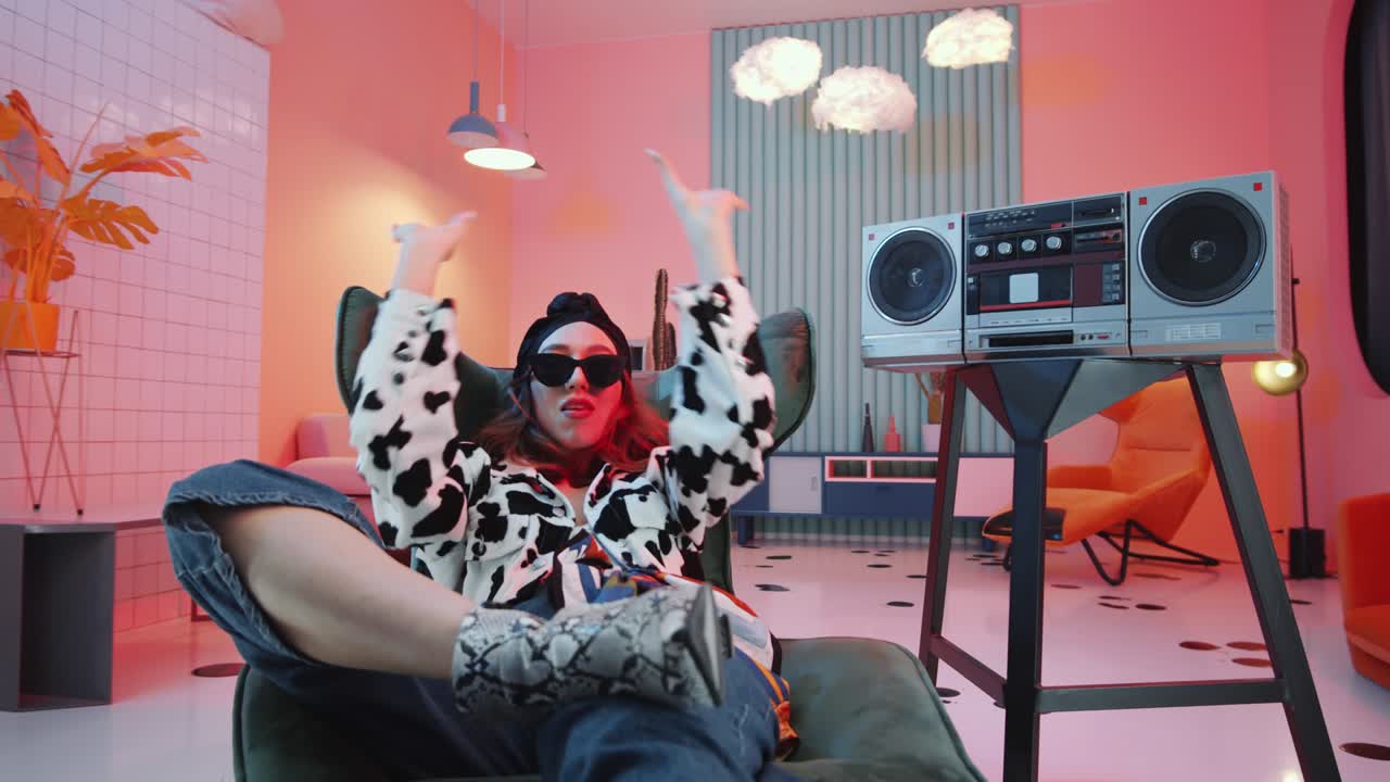 mujer chic descansando en un sillón y vagando para la cámara en un estudio vintage