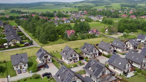 Toma-Aérea-Del-Barrio-Moderno,-Casas-Unifamiliares-Y-Campos.