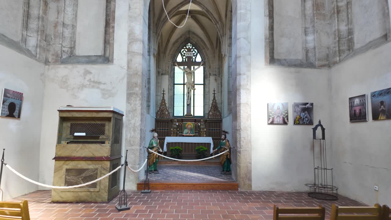 Interior of Sedlec Ossuary in Kutná Hora, Czech Republic, with wooden chairs and a small altar