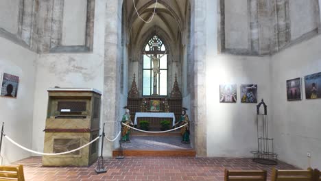 interior of sedlec ossuary in kutná hora, czech republic, with wooden chairs and a small altar