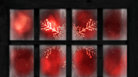 animation of snow falling over christmas snowflake seen through window