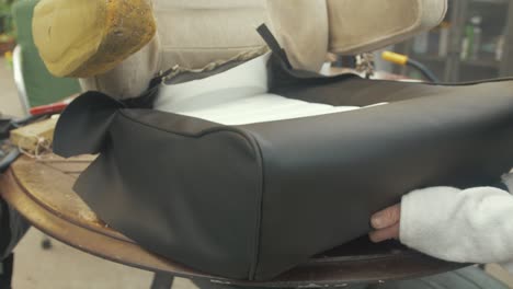 woman's hands fitting reupholstered car seat leatherette