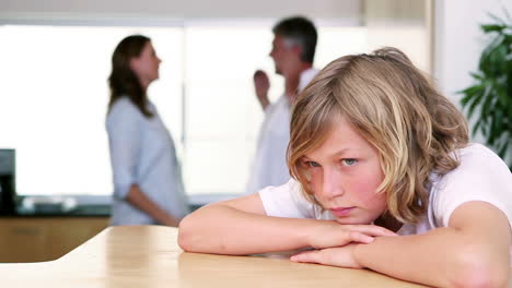 little boy sighing while listening to his parents