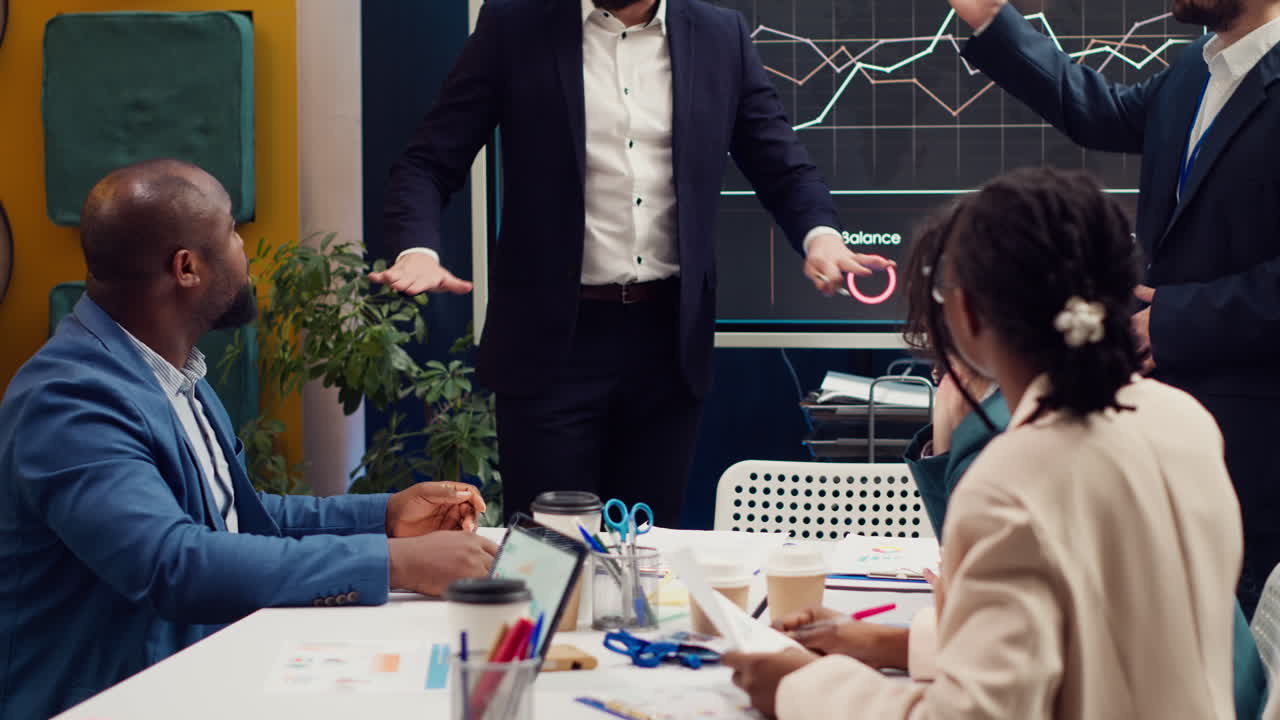El líder del equipo entra en la sala de reuniones y habla con sentido a sus empleados
