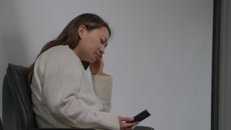 mujer estresada o ansiosa en el trabajo en un edificio de oficinas reaccionando a un mensaje o historia de noticias en internet o redes sociales en un teléfono móvil 5