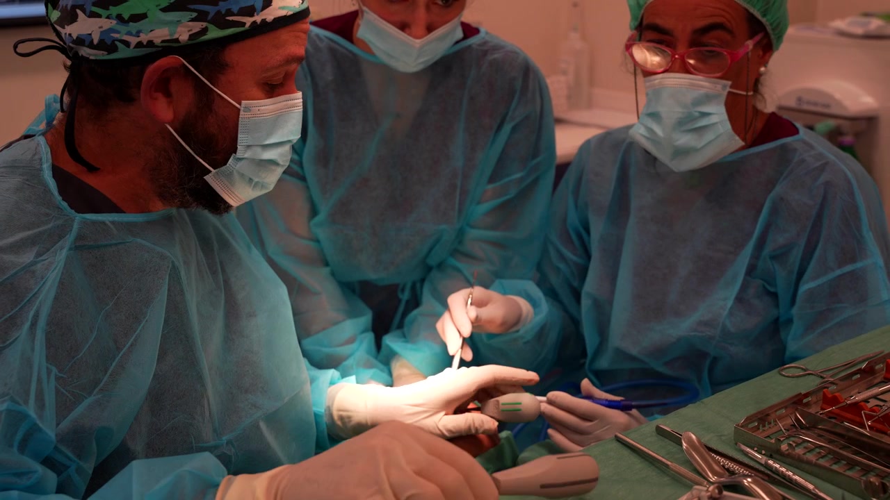 Procedura odontoiatrica con dentisti che eseguono un intervento di estrazione dentale e aspirazione del sangue.