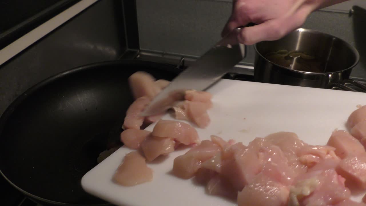 trozos de pollo en rodajas que se ponen en una sartén para freír