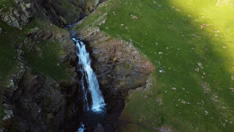 Circular-travelling-view-of-a-waterfall-formed-by-thaw-in-a-mountain-valley