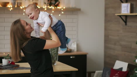 Madre-Y-Su-Hijo-Divirtiéndose-Y-Jugando-En-Casa.-Un-Niño-De-2-Años-Juega-Con-Los-Brazos-De-Su-Madre-En-Casa-Cerca-De-Una-Ventana-Grande