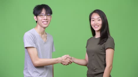 young asian couple shaking hands