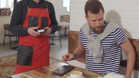 cliente pagando por el café en una cafetería