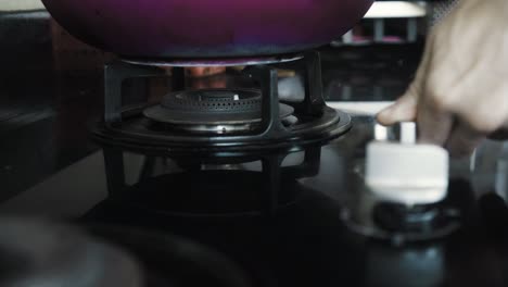 video of a black gas stove with blue and red burning flame in the kitchen