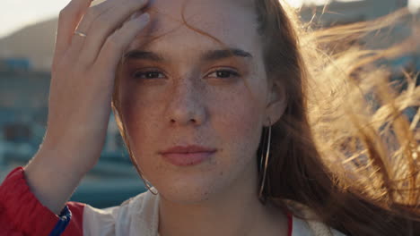 Retrato-Hermosa-Adolescente-Sonriendo-Luciendo-Feliz-Con-El-Viento-Que-Sopla-Mujer-De-Pelo-Rojo-Disfrutando-De-Una-Imagen-Positiva-De-Sí-Mismo-En-La-Ciudad-Al-Atardecer