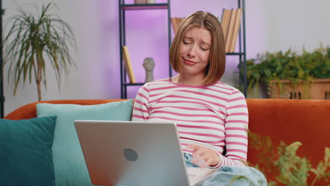 pretty young woman use laptop surprised by bad news fortune loss fail lottery results at home