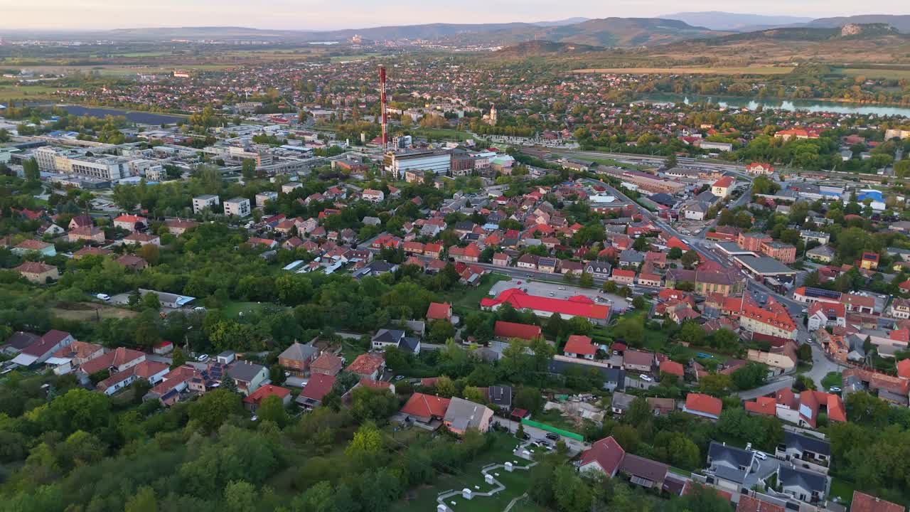 Orbital drone video around the Dorog industrial downtown and suburban area during sunset in Hungary