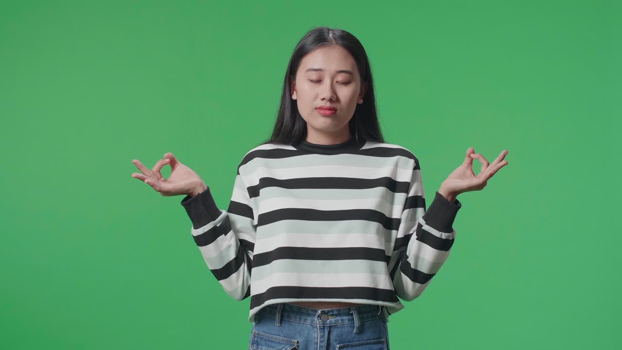 Asian Woman Concentrate In Front Of Green Screen Background