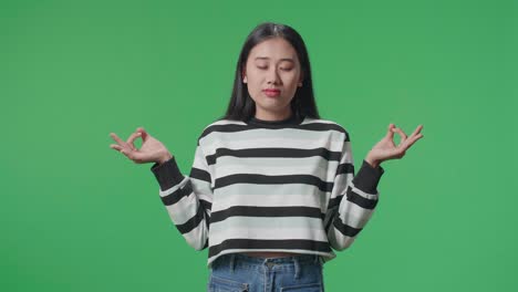 asian woman concentrate in front of green screen background