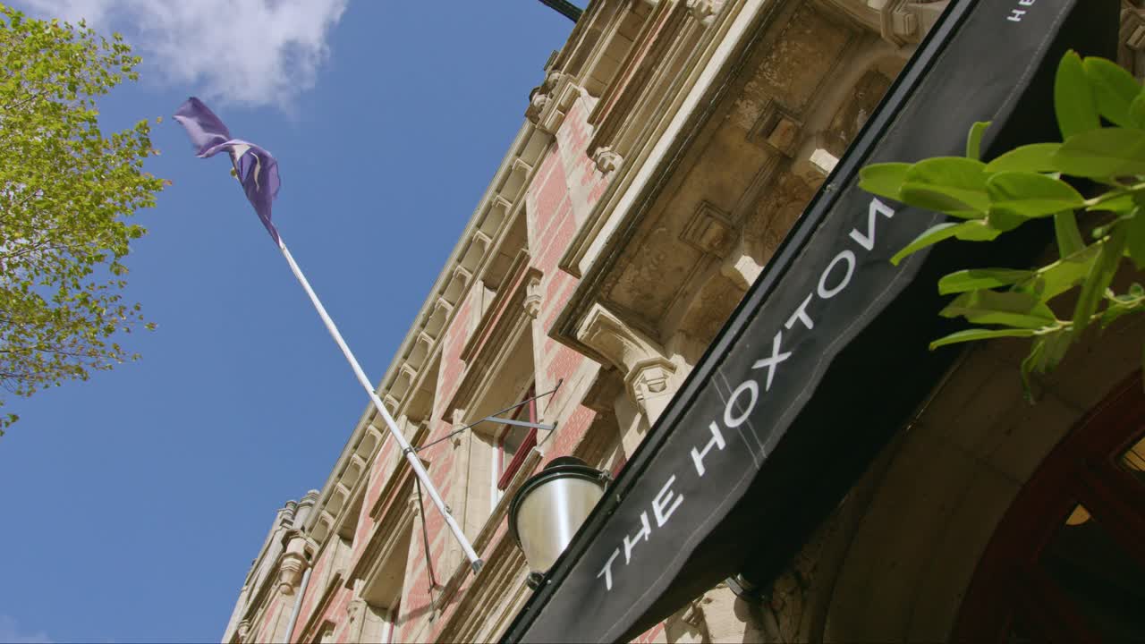 Una bandiera viola che sventola sulla facciata del The Hoxton, Amsterdam, a Herengracht, Amsterdam, Paesi Bassi.