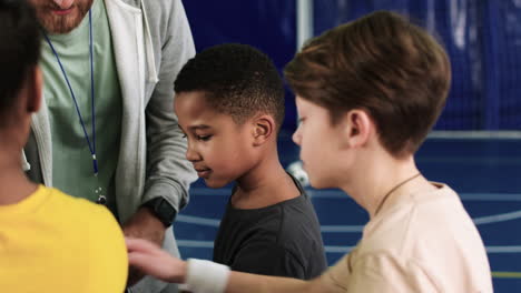 kids and trainer with hands on the center