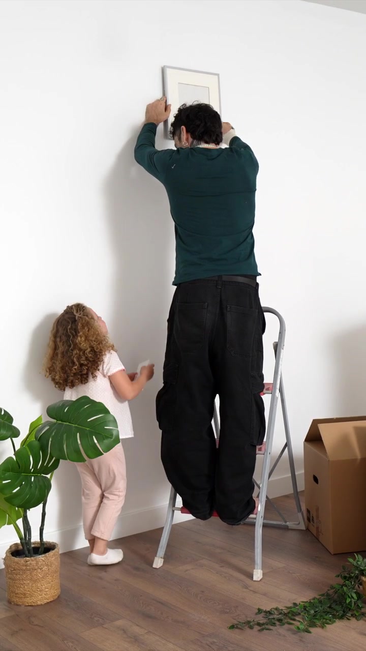 Father and Daughter Decorating New Home Together