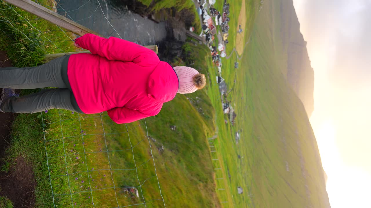 행복 한 여성 관광객 이 gjogv 전망대 에서 일몰 을 즐긴다, 페로 제도