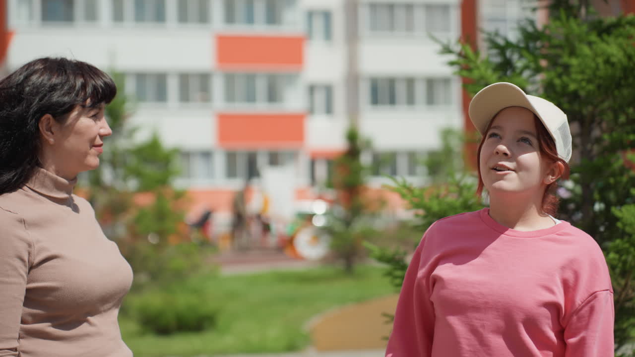 Mentorship In Sunlight, Woman Guides Teen Peacefully Outside, Calm Exchange Between Neighbor And Mentor Outdoors, Gentle Conversation Takes Place Between Woman And Teen Under Sunlight