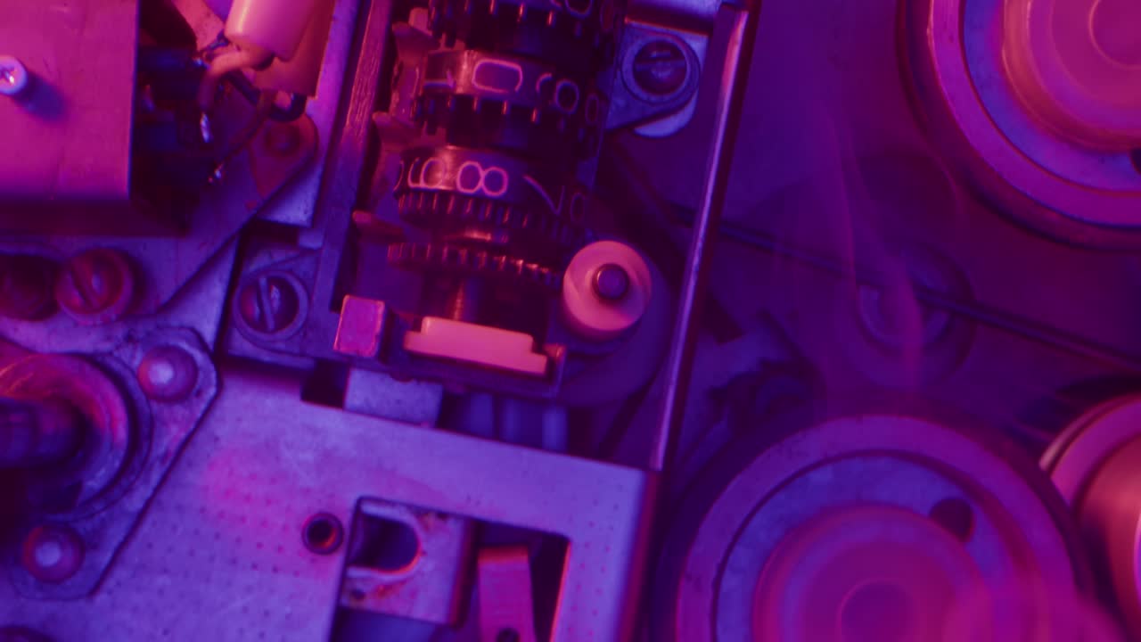 vista de cerca de intrincadas piezas de máquinas antiguas bajo una brillante iluminación de neón
