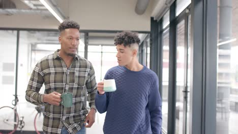 Busy-diverse-businessmen-talking-and-walking-with-coffee-in-office-in-slow-motion