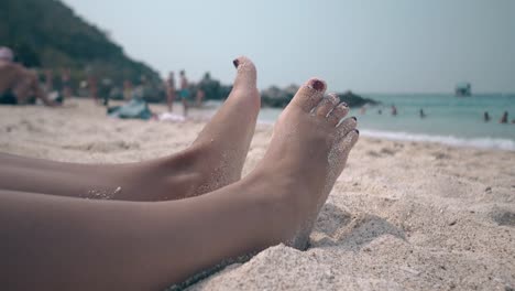 ocean-waves-sparkle-in-bright-sun-and-relaxing-woman-feet